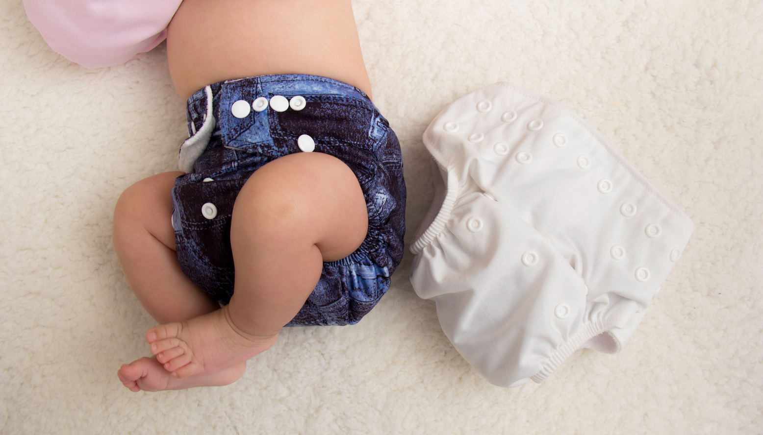 Baby lying down wearing cloth diaper